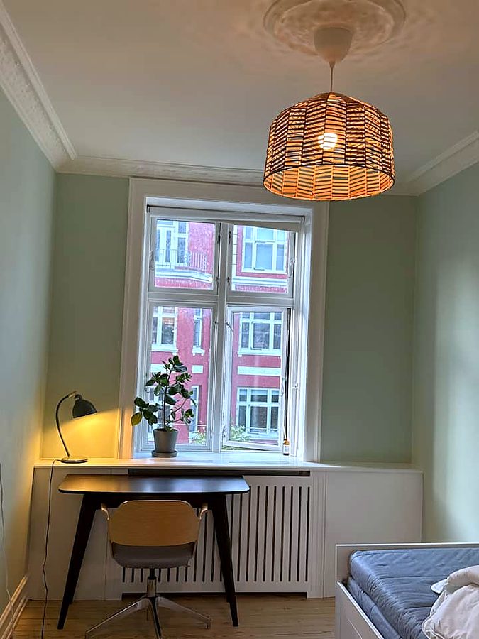 Skrivebord ved vinduet med kontorstol og lampe